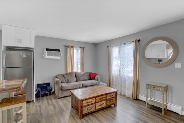 living room featuring light wood-style floors, a wall unit AC, plenty of natural light, and baseboard heating