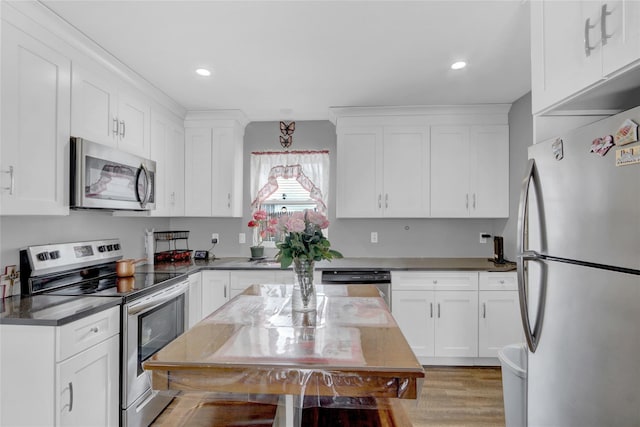 kitchen with light wood-style flooring, recessed lighting, stainless steel appliances, white cabinets, and dark stone countertops