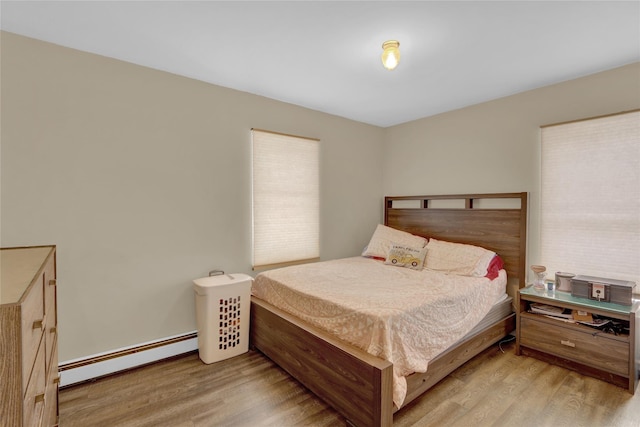 bedroom with light wood-style flooring and baseboard heating