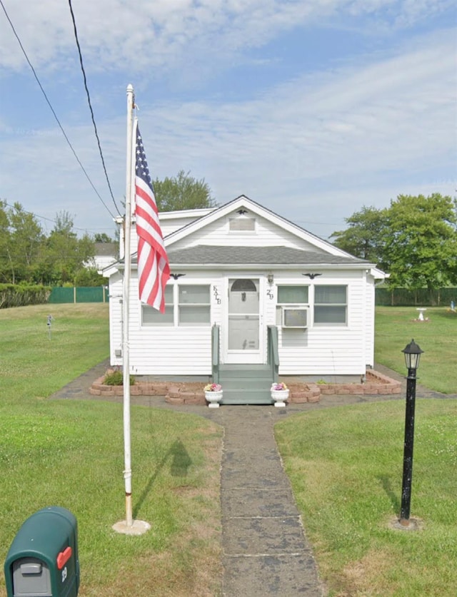 bungalow-style home with entry steps and a front yard