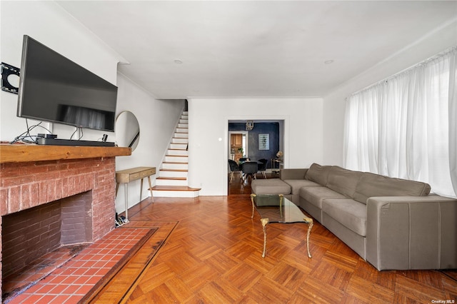 living room with stairs and a brick fireplace