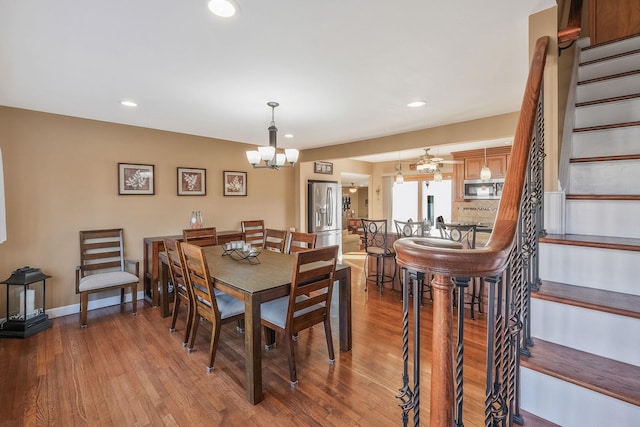 dining space with stairs, baseboards, wood finished floors, and recessed lighting