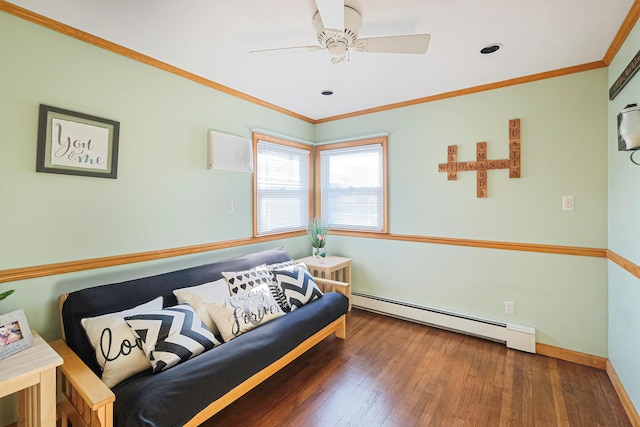 living area featuring dark wood finished floors, baseboard heating, ornamental molding, ceiling fan, and baseboards