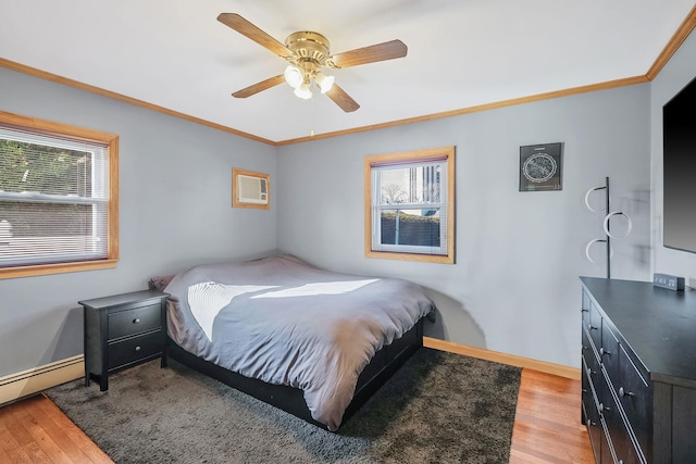 bedroom featuring light wood-style flooring, a ceiling fan, baseboards, baseboard heating, and crown molding