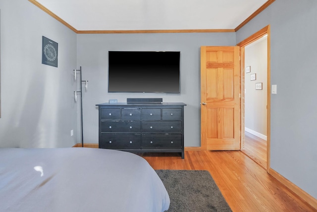 bedroom featuring crown molding, baseboards, and wood finished floors