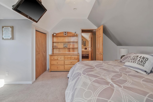 bedroom featuring light carpet, a ceiling fan, baseboards, vaulted ceiling, and a closet