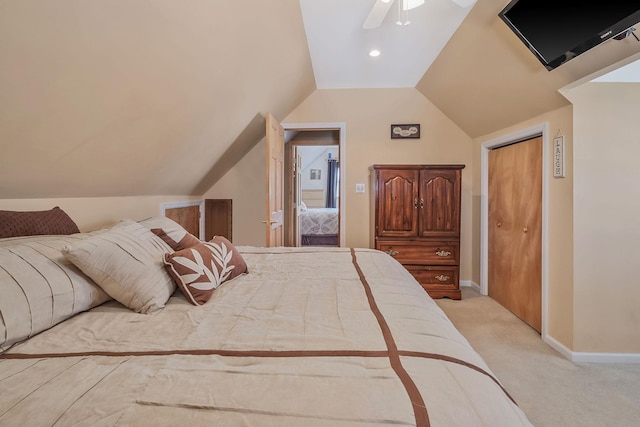 bedroom featuring baseboards, a ceiling fan, light colored carpet, lofted ceiling, and a closet