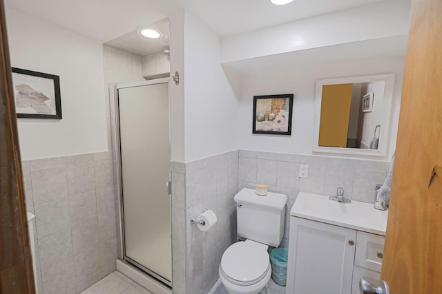 full bath featuring toilet, a stall shower, tile walls, and vanity