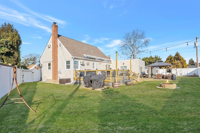 back of property featuring a fenced backyard, a fire pit, a gazebo, a gate, and a chimney