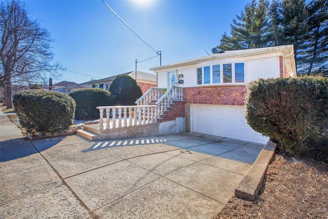 view of front of house featuring a garage, concrete driveway, and brick siding