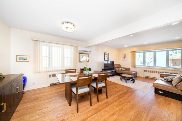 dining space with light wood finished floors, radiator heating unit, and a wall mounted AC