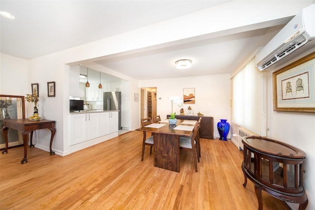 dining space featuring light wood-type flooring, radiator heating unit, a wall unit AC, and baseboards