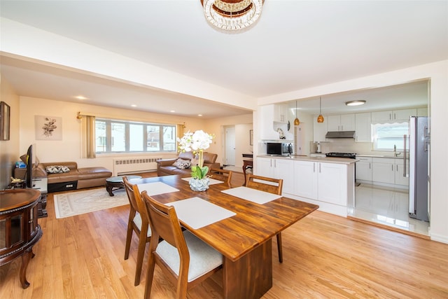 dining space featuring recessed lighting, radiator, a healthy amount of sunlight, and light wood-style flooring