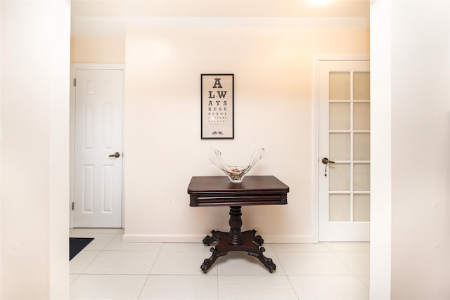 hallway with baseboards and light tile patterned flooring