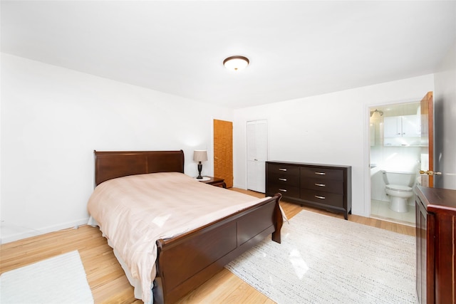 bedroom featuring light wood-type flooring, connected bathroom, and baseboards