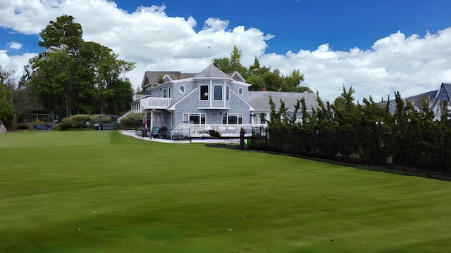 back of house featuring a lawn and fence