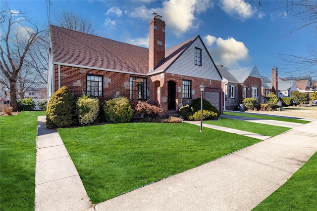 view of front facade with a garage, a shingled roof, a chimney, a front lawn, and brick siding