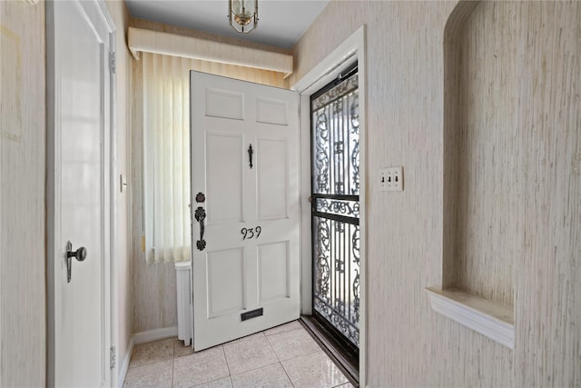 entrance foyer with light tile patterned flooring and wallpapered walls