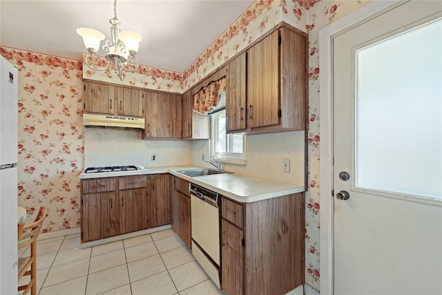 kitchen featuring wallpapered walls, under cabinet range hood, light countertops, and dishwasher