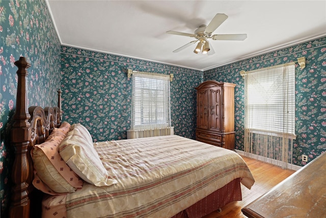 bedroom with baseboards, light wood finished floors, a ceiling fan, and wallpapered walls