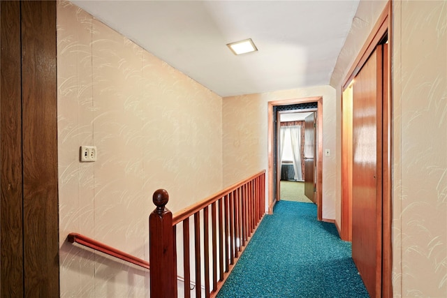 corridor featuring carpet flooring and an upstairs landing