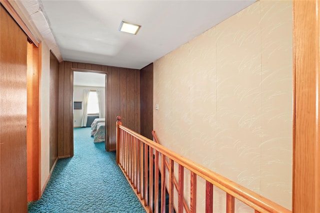 hall featuring an upstairs landing, dark colored carpet, and radiator heating unit