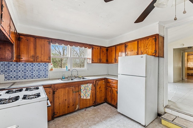 kitchen with brown cabinets, light countertops, decorative backsplash, a sink, and white appliances