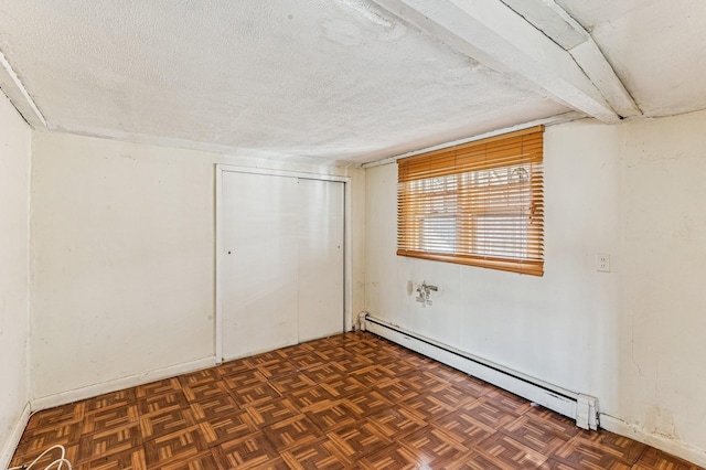 empty room with a textured ceiling and baseboard heating