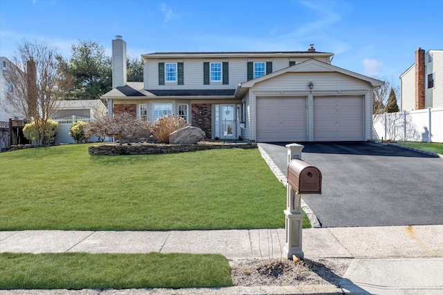 traditional-style house with driveway, a chimney, an attached garage, fence, and a front yard