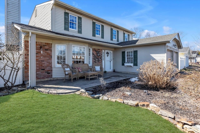 view of front of property featuring a garage, a chimney, a patio area, a front lawn, and brick siding