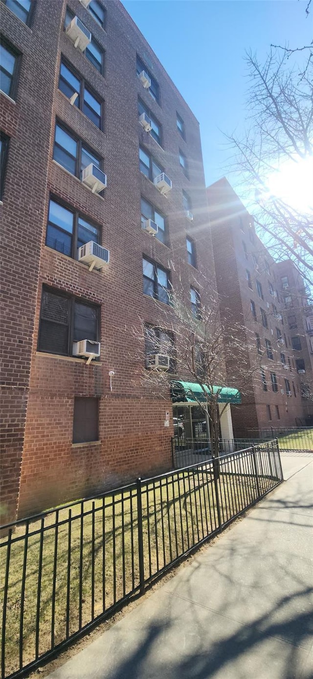 view of building exterior with fence and cooling unit