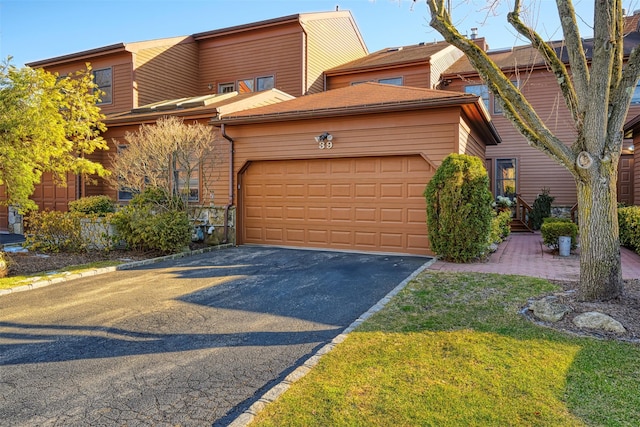 view of front of house featuring an attached garage and aphalt driveway