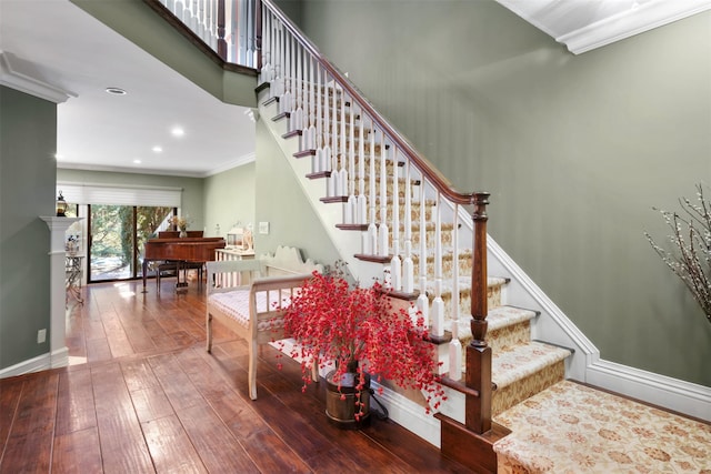 stairway featuring wood-type flooring, ornamental molding, baseboards, and recessed lighting