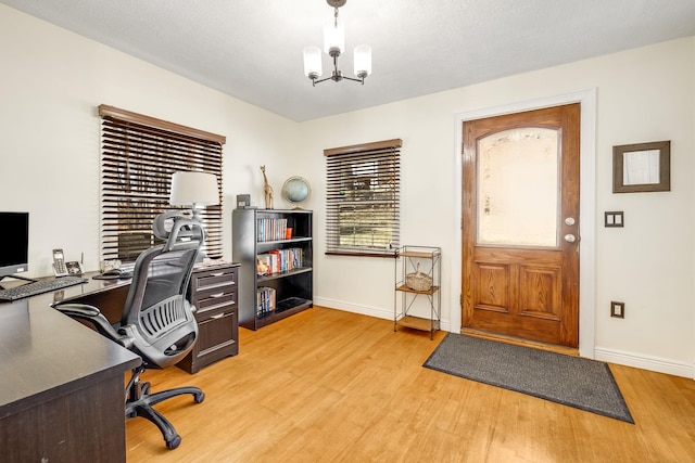 office with a chandelier, light wood-style flooring, and baseboards