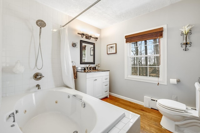 full bath featuring toilet, a baseboard heating unit, vanity, a textured ceiling, and wood finished floors