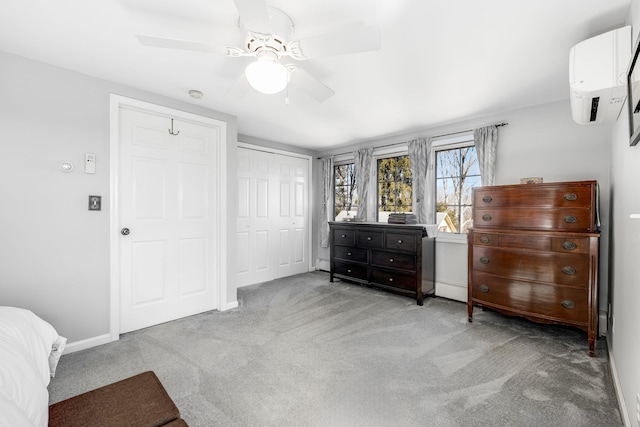 bedroom featuring carpet flooring, a ceiling fan, baseboards, a closet, and a wall mounted air conditioner