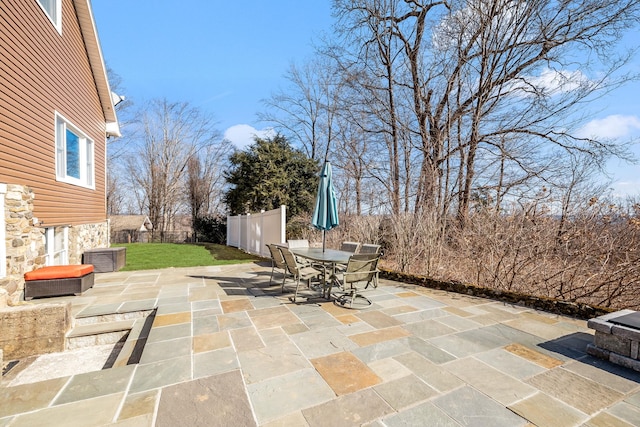 view of patio with outdoor dining space and fence