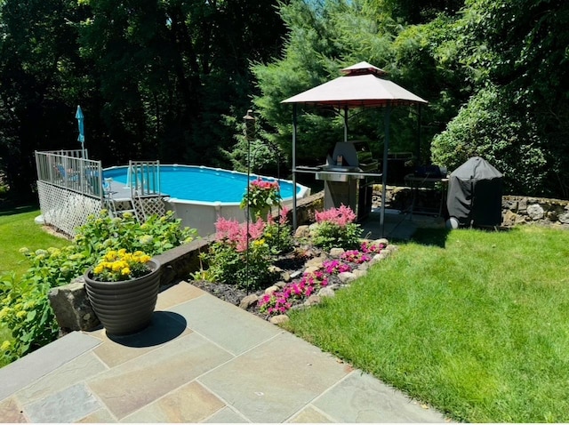 outdoor pool featuring a yard and a patio