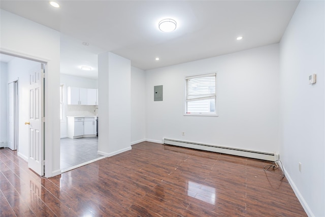 unfurnished room with a baseboard heating unit, recessed lighting, dark wood-style flooring, and electric panel