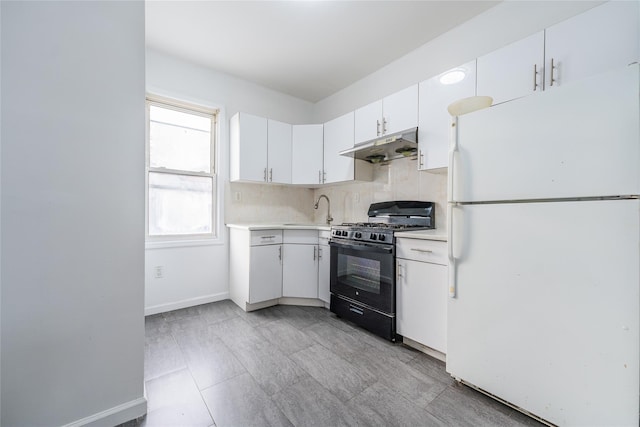 kitchen featuring light countertops, black gas range, freestanding refrigerator, white cabinetry, and under cabinet range hood