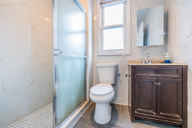 full bathroom with tile walls, toilet, vanity, and a shower stall