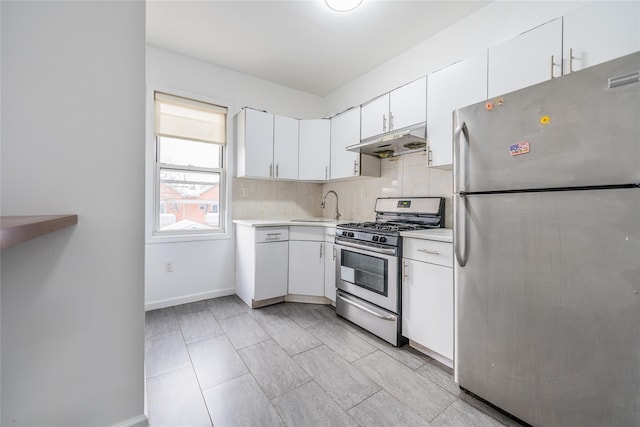 kitchen with light countertops, backsplash, appliances with stainless steel finishes, white cabinets, and under cabinet range hood