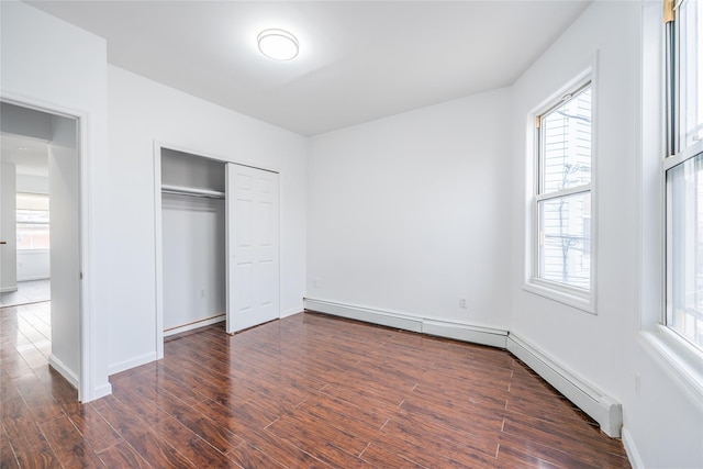 unfurnished bedroom with dark wood-style flooring, a closet, and baseboards