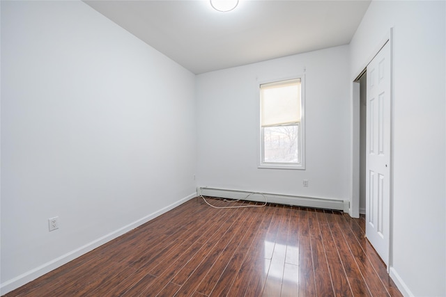 unfurnished bedroom with dark wood-style floors, a baseboard radiator, and baseboards