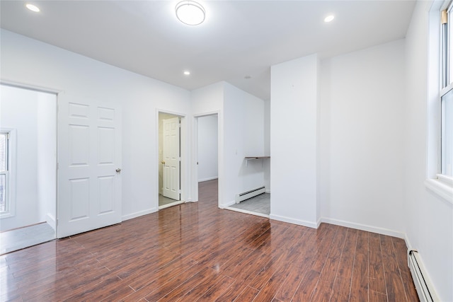 unfurnished bedroom with a baseboard heating unit, dark wood-style floors, and recessed lighting