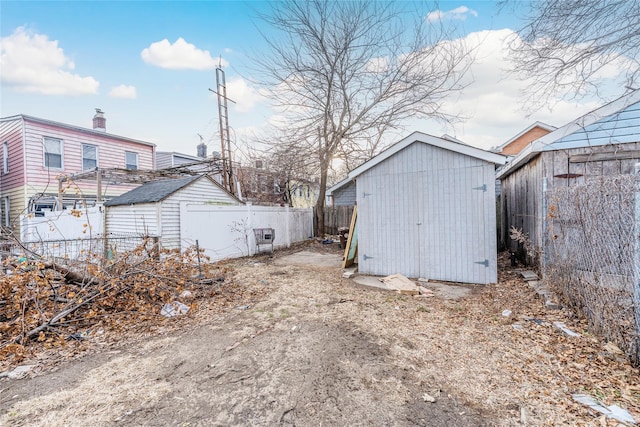 exterior space featuring an outdoor structure, fence, and a storage unit