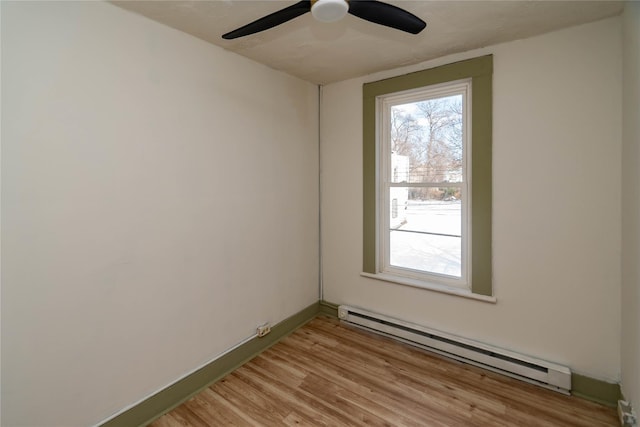 unfurnished room featuring a healthy amount of sunlight, ceiling fan, a baseboard radiator, and light wood-style flooring