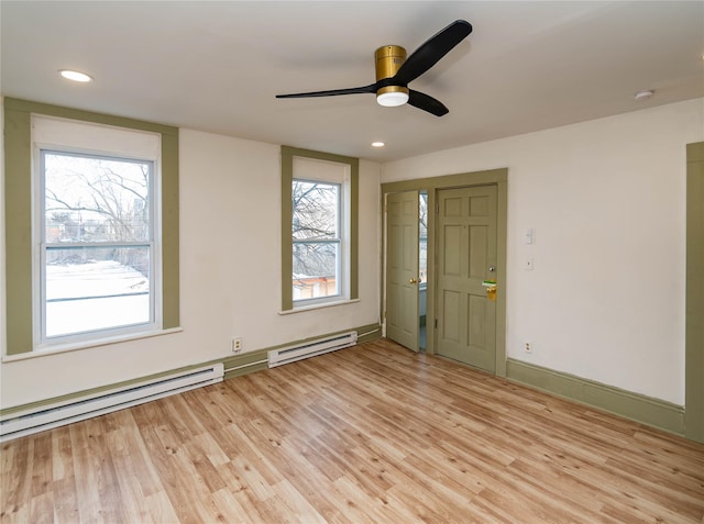 unfurnished room with light wood finished floors, a baseboard radiator, recessed lighting, and baseboards