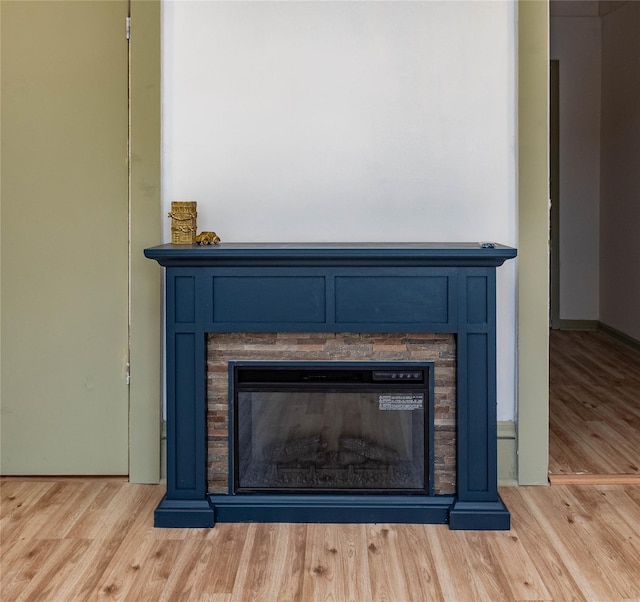 room details featuring a glass covered fireplace and wood finished floors