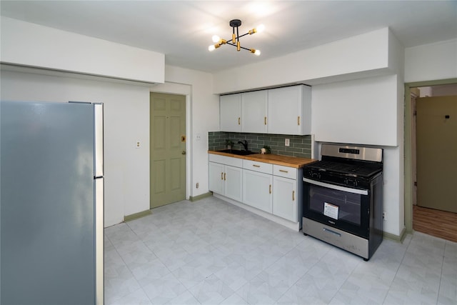 kitchen with stainless steel appliances, butcher block counters, white cabinetry, and a sink